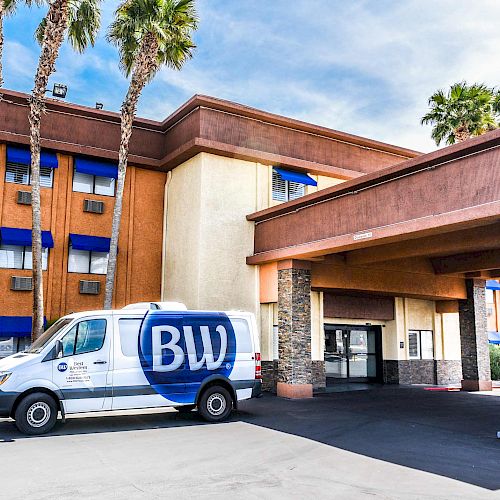 A hotel entrance with a van marked 