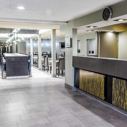 The image shows a modern, empty dining area with tables and chairs, a front desk, and a 'Welcome to Las Vegas' sign on the wall.